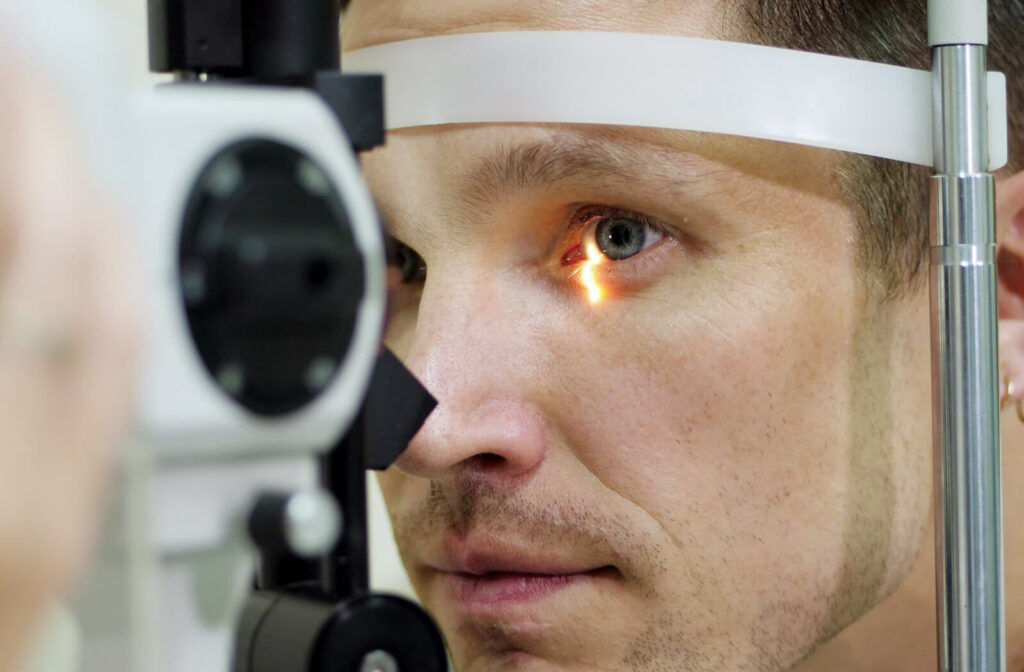 A man doing an eye test with a non-contact tonometer to check his eyes for glaucoma.