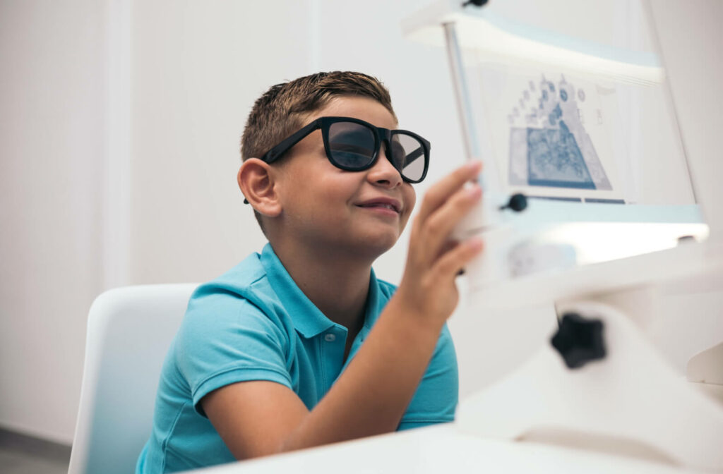 A child wearing glasses with lenses that have different tints while performing a vision therapy exercise.