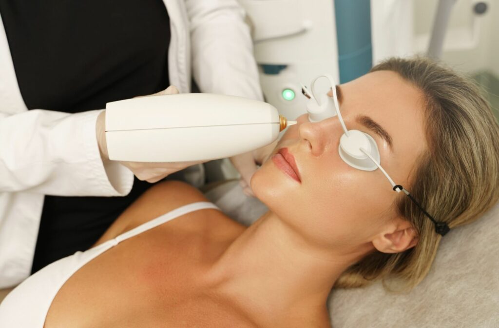 Close-up of a woman receiving an IPL treatment from an optometrist using a specialized equipment.