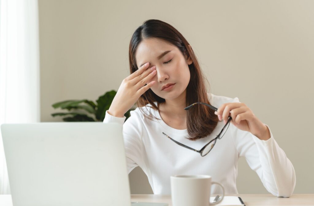 a person rubbing the bridge of their nose to alleviate headache symptoms.