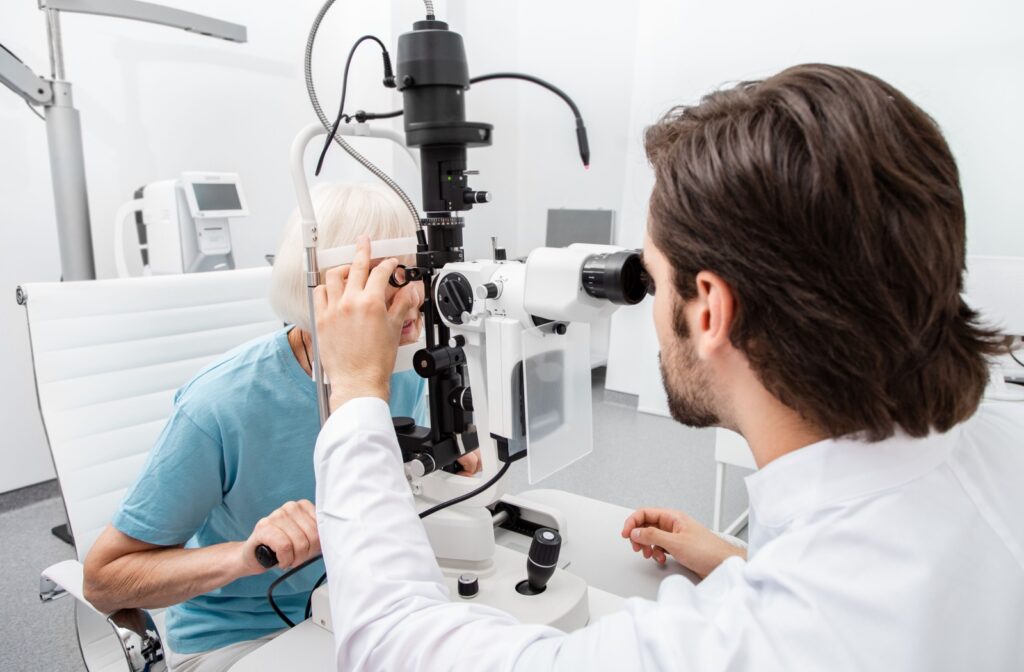 An optometrist carefully examining the eyes of an older adult to diagnose the cause of their recent vision changes.