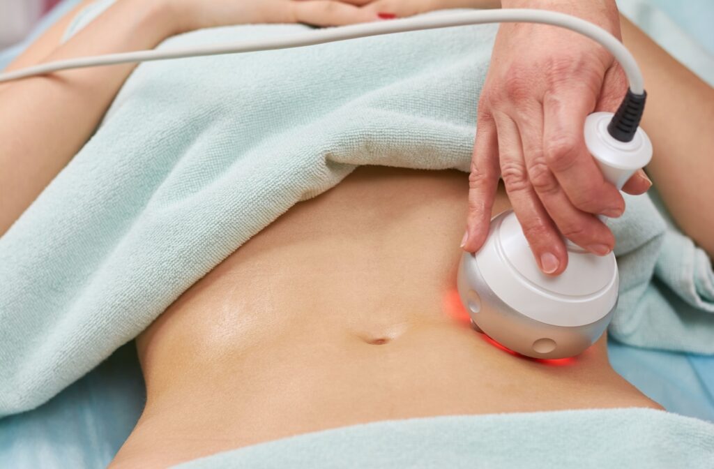 A close-up of a radiofrequency device being used on a woman's stomach.