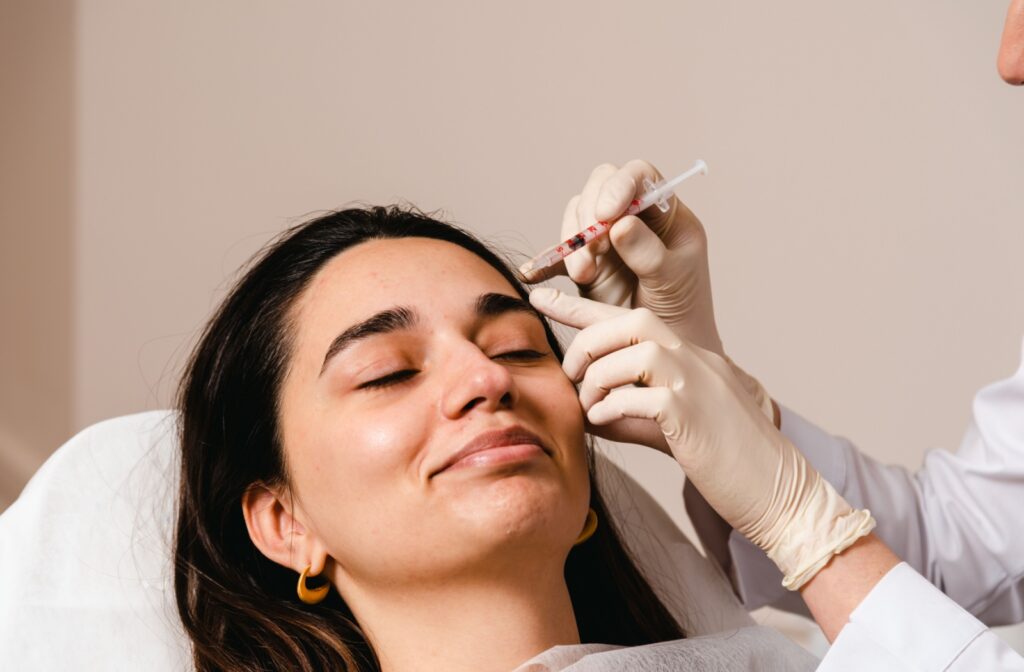 An adult gets a Botox injection in their forehead as part of their migraine prevention treatment.
