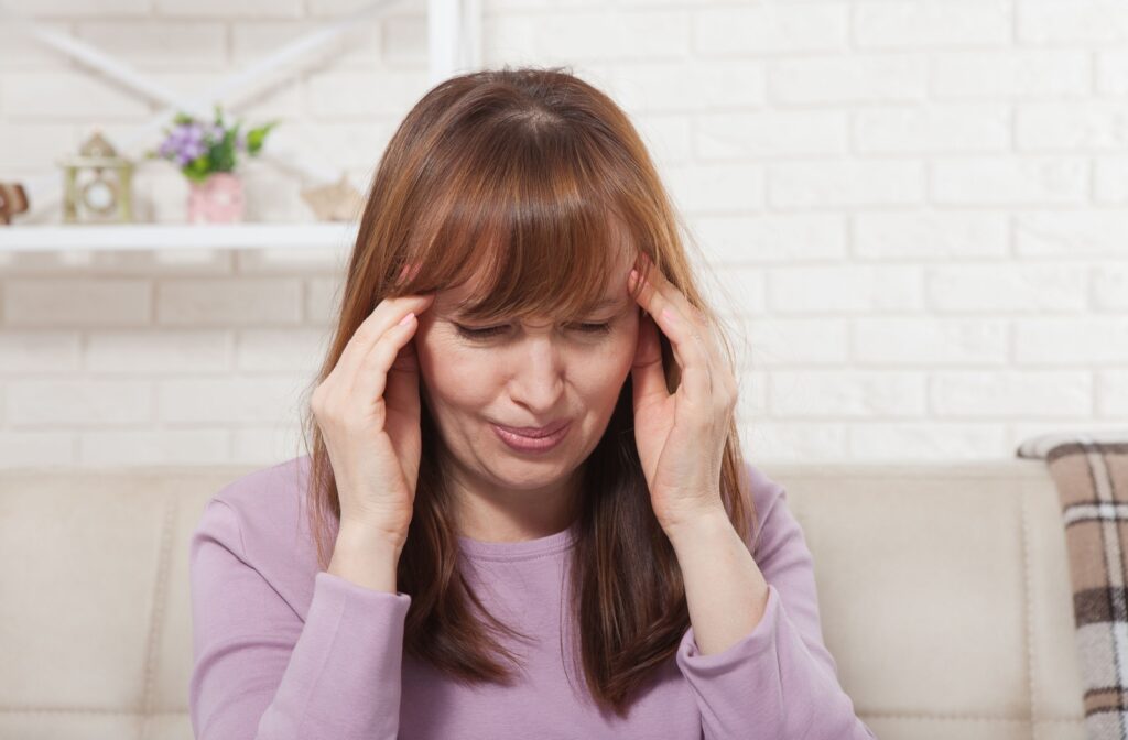 An adult holds their head as they deal with the pain from a migraine headache.
