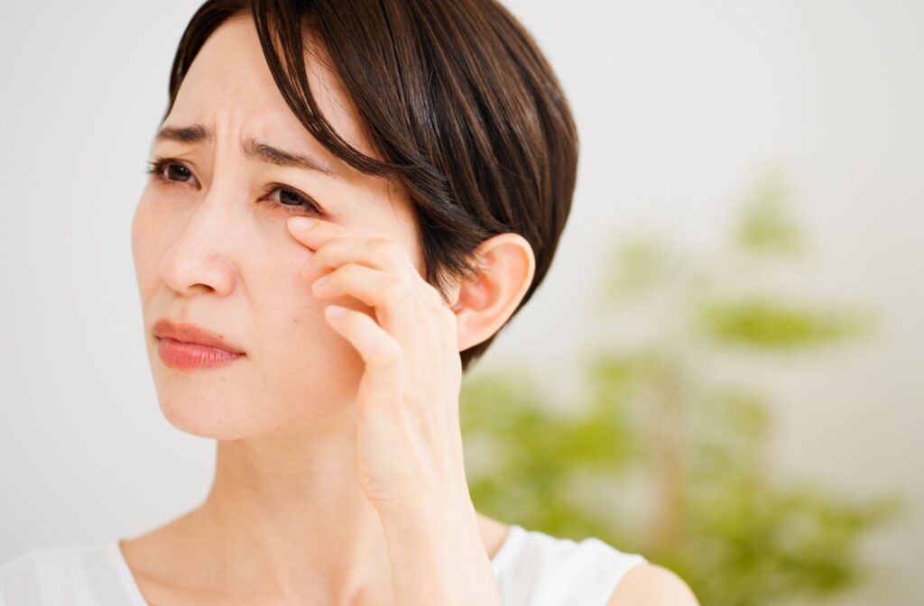 A person rubbing their eyes that are irritated caused by their dry eyes