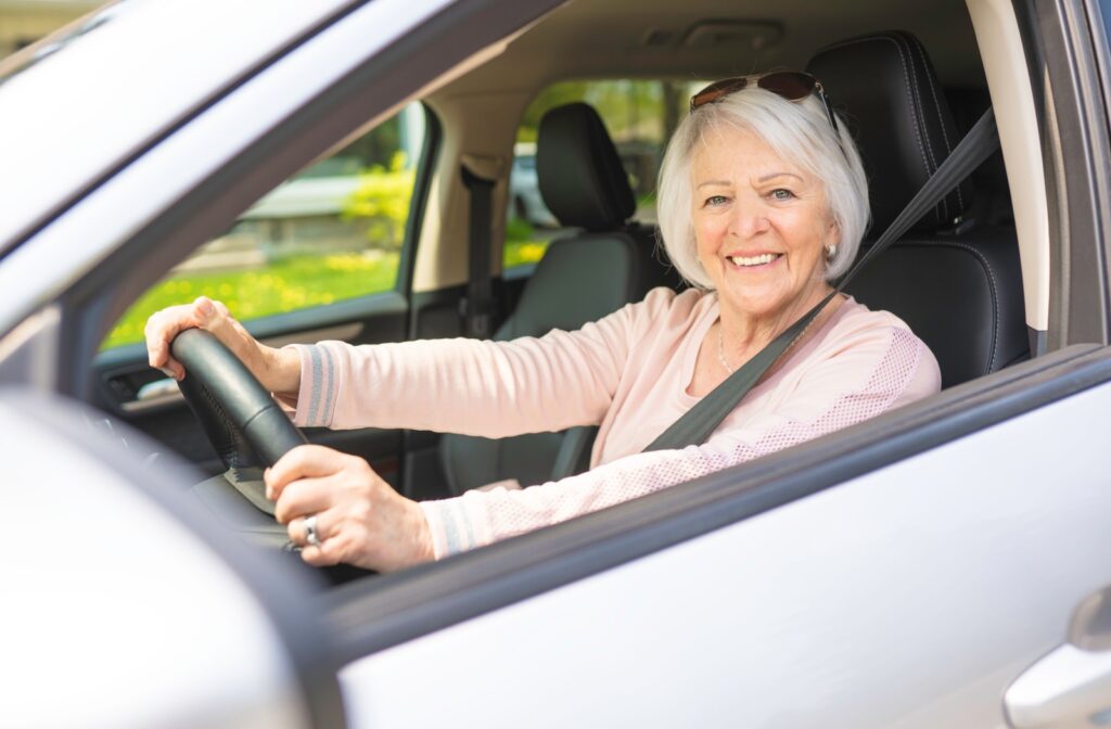 A senior citizen driving a car after cataract surgery