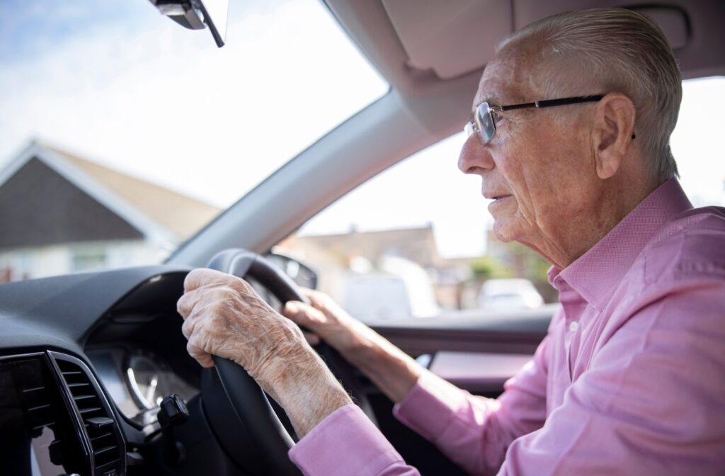A senior citizen driving a car while wearing glasses