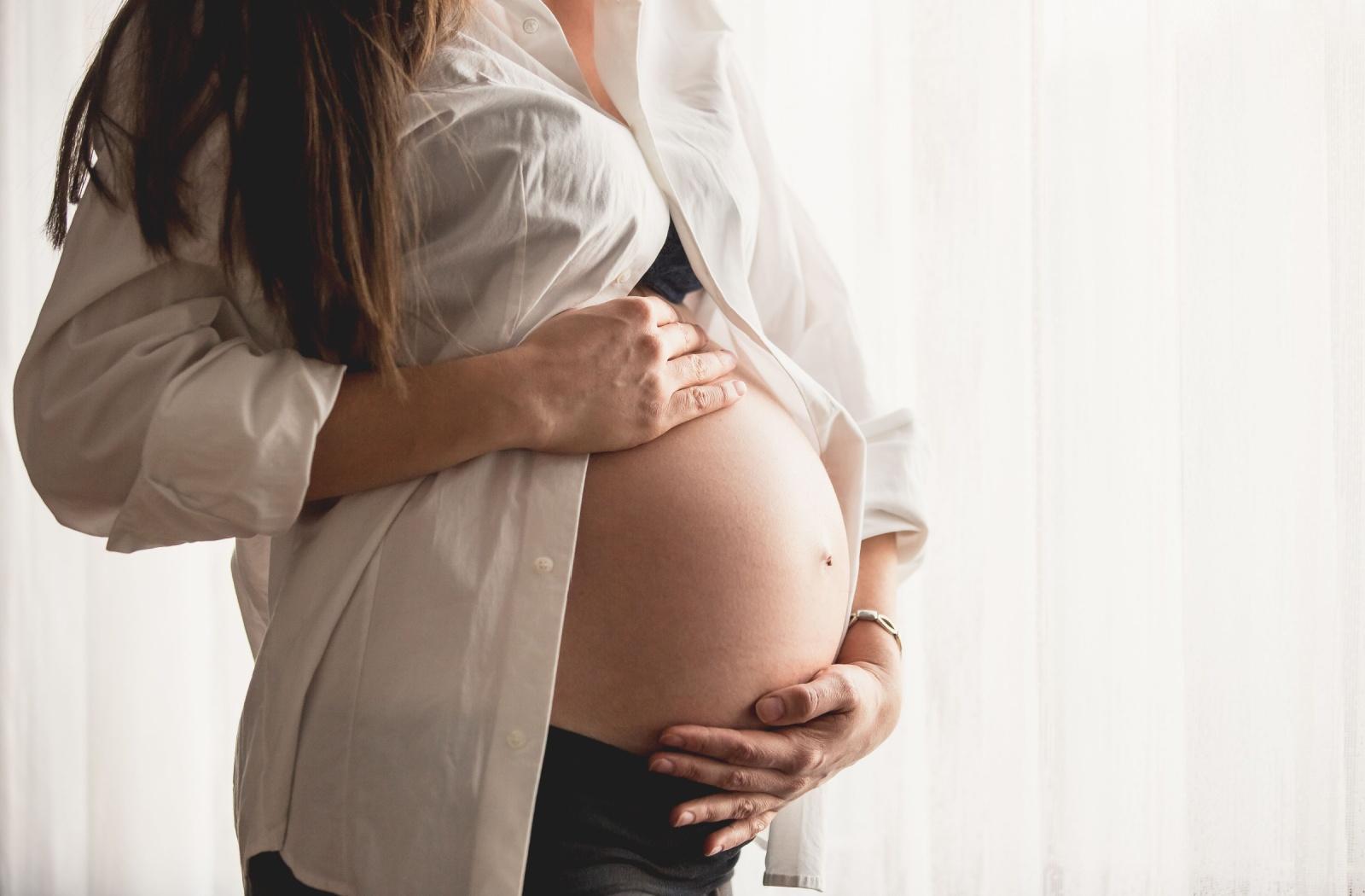 A pregnant woman holding her belly